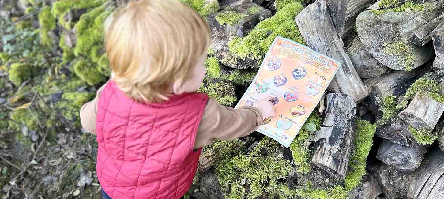 Kind mit Herbstbingo in der Natur