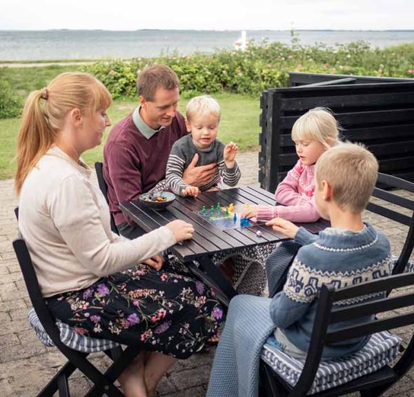 Familie spielt ein Brettspiel im Ferienhaus in Hasmark