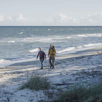 Par går tur på stranden ved Flyvesandet