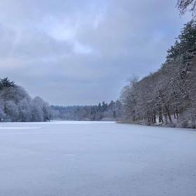 Langesø im Winter mit Schnee auf dem Weg und Bäumen und Eis auf dem See